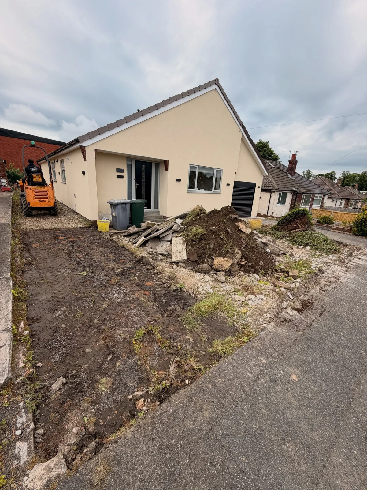 Work underway at the Gomersal property showing excavated ground, lifted paving and a mini digger