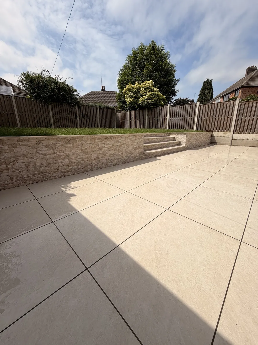 Completed porcelain patio, retaining wall, steps and raised lawn